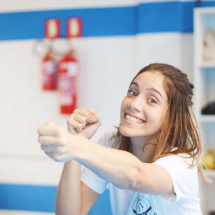 Patrícia sorrindo enquanto dá um golpe de boxe